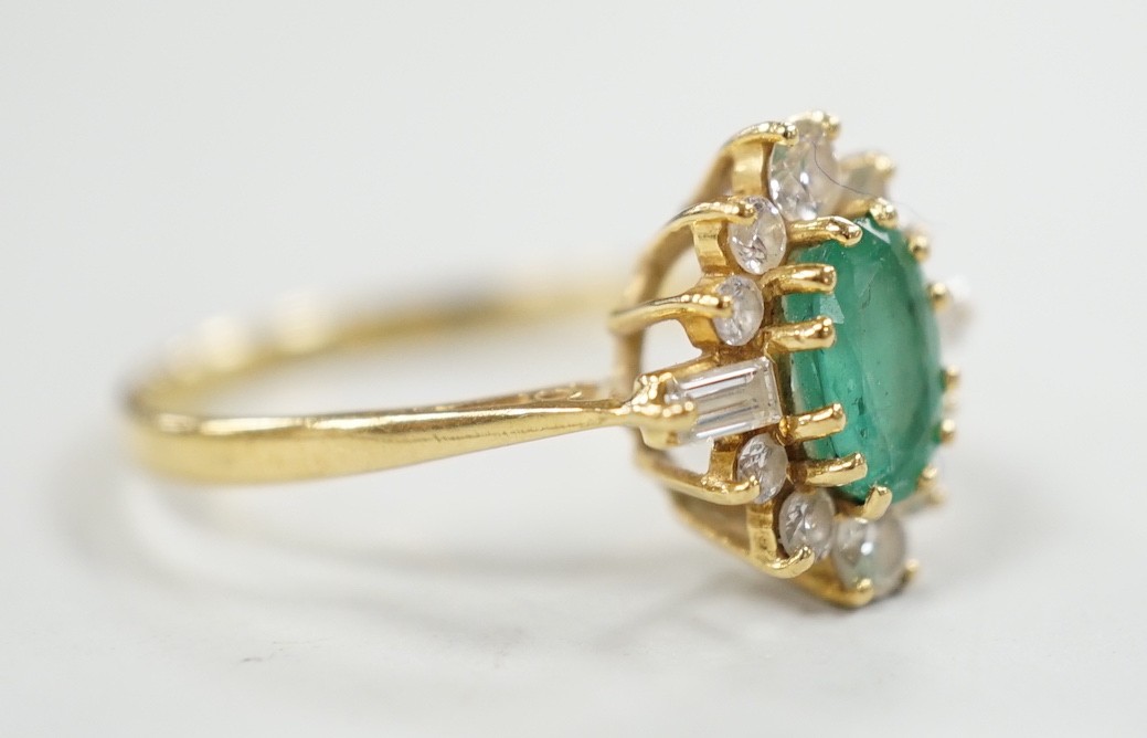 A modern 18ct gold, single stone oval cut emerald and round and baguette cut diamond cluster set ring, size P/Q, size 3 grams.